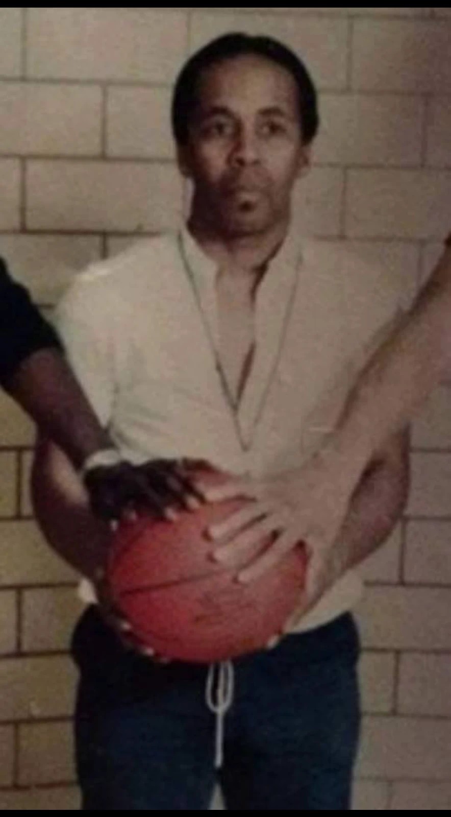 Bob Kaiser holding a basketball in the gym during his coaching years